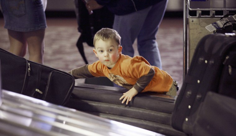 Child looks for luggage in terminal at airport in Phoenix, Arizona