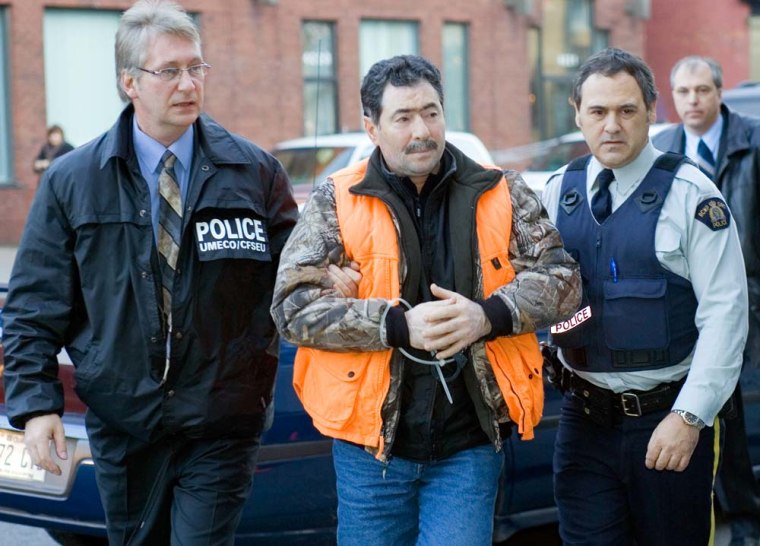 Francesco Arcadi is escorted into the Royal Canadian Mounted Police headquarters in Montreal, on Wednesday, following a raid on a Mafia ring. 