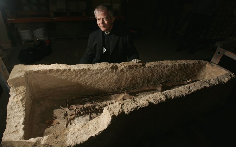 A Roman limestone sarcophagus containing a headless skeleton is prepared for display at the Museum of London, after being discovered by archaeologists during renovations at St Martin-in-the-Fields Church. The Rev. Nicholas Holtam, the church's vicar, surveys the sarcophagus on Thursday.