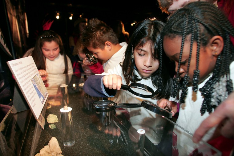 Kids from Hollingsworth Elementary School examine future Nevada State Museum exhibits, including a dinosaur bone, on Thursday in Las Vegas. The Nevada State Museum held a ceremony previewing some of the artifacts it will display when the new facilities open in 2008 at the Springs Preserve.
