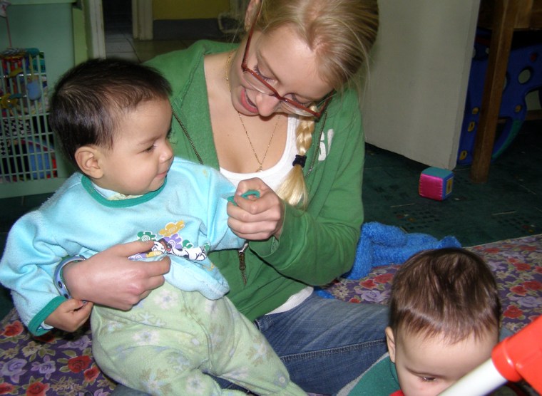 In this photo released by Global Volunteers, Lilly Fisher plays with a girl named Mihaela while volunteering at Tutova Hospital's Failure to Thrive Clinic in Tutova, Romania, January 2006. (AP Photo/Global Volunteers)