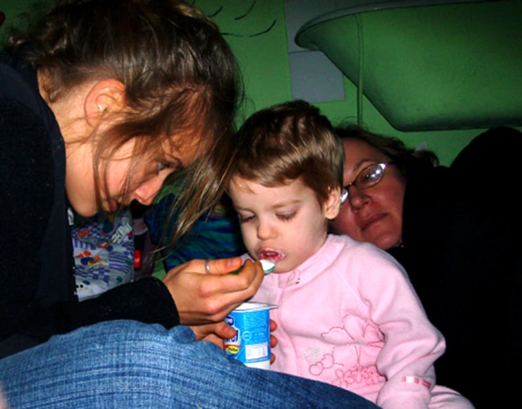 In this photo released by Global Volunteers, Emma Fisher feeds a girl named Ana-Maria while volunteering at Tutova Hospital's Failure to Thrive Clinic  in Tutova, Romania,January 2006. AP Photo/Lilly Fisher)