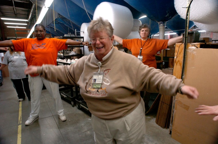 Linda Jackson laughs at her dancing while participating in a stretching routine while at work at Replacements, Ltd. in Greensboro, N.C., on Tuesday, Nov. 14, 2006. Twice a day the warehouse staff is encourage to stretch and loosen up their upper body to counteract their repetitive routine on an assembly line. (AP Photo/Sara D. Davis)