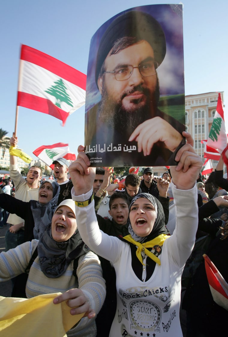 Hezbollah supporters hold posters of leader Sheikh Hassan Nasrallah and wave Lebanese flags during an anti-government protest in Beirut on Dec. 2.
