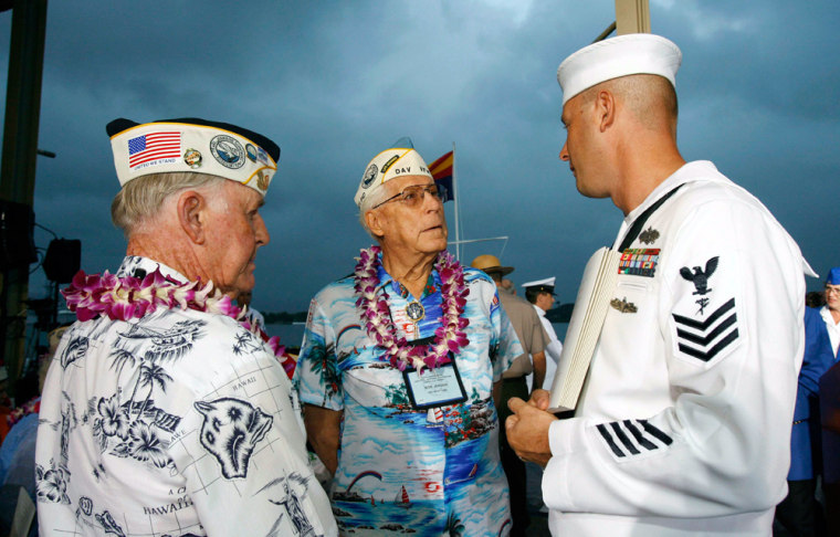 Pearl Harbor survivors speak with U.S. Navy CE1 Scott Hanneman at the memorial ceremony honoring the 65th anniversary of the attack on Pearl Harbor in Honolulu