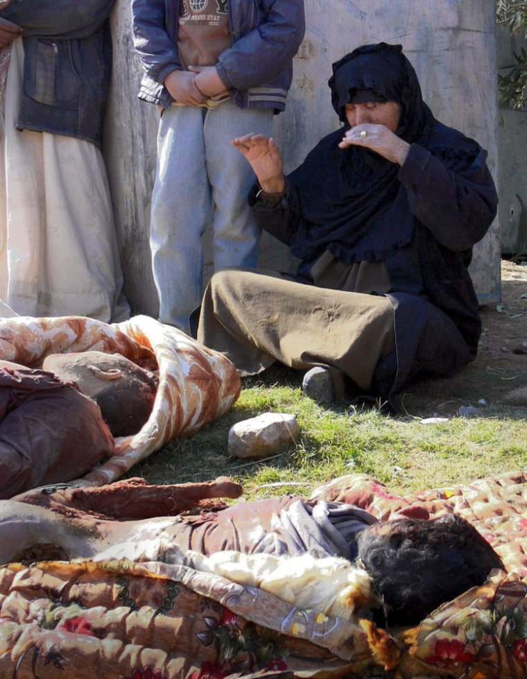 An Iraqi woman weeps next to the bodies