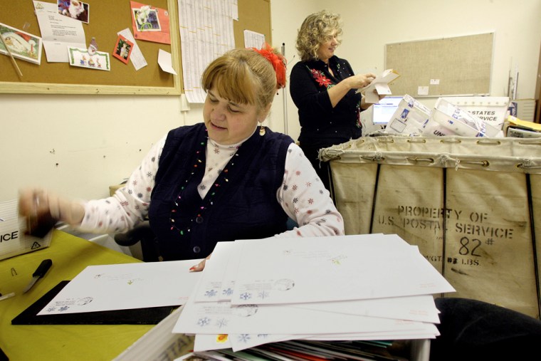 Marcia Bernier, front, a worker at the Fairbanks, Alaska, post office, stamps the North Pole cancellation on letters addressed to Santa Claus.