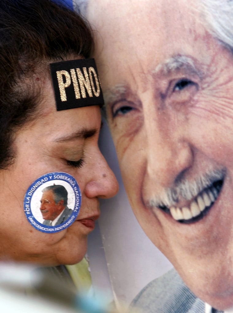 A supporter of former Chile dictator Augusto Pinochet places her forehead on a poster of him outside the Military Hospital in Santiago where he died Sunday.