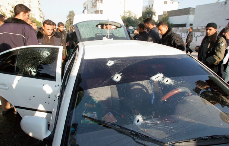 Palestinian security officers guard vehicle which unidentified gunmen shot at, killing three sons of Palestinian intelligence chief loyal to President Abbas, in Gaza