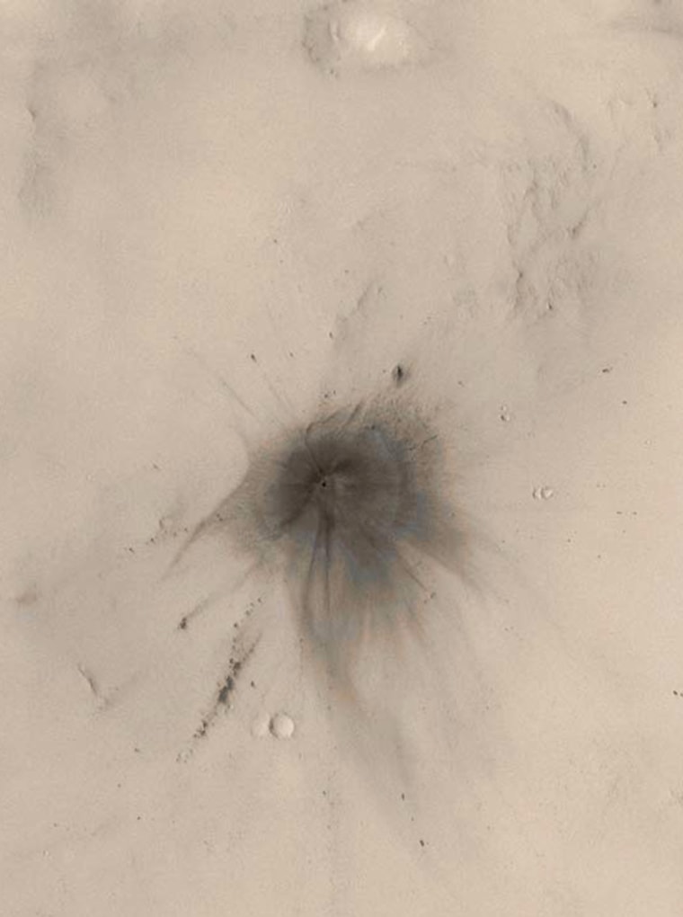 Wispy dark rays and dark, annular (nearly-circular) zones surround a newfound Mars crater. Scientists used the Mars Orbiter Camera to photograph about 30 percent of the planet. 