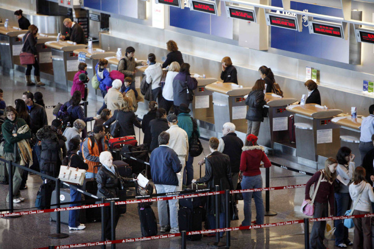 Travellers stand in line at the Delta Airlines counter at Logan Airport in Boston