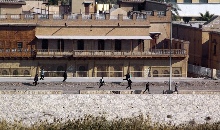 Iraqis run for cover during a gunfight i