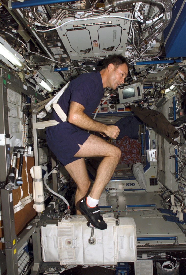 Space station commander Michael Lopez-Alegria watches movies during his daily exercise routine.