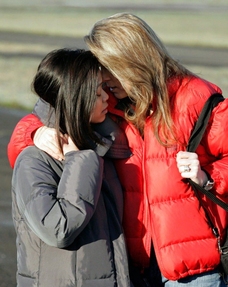 Wives of stranded climbers console each other at the Hood River airport