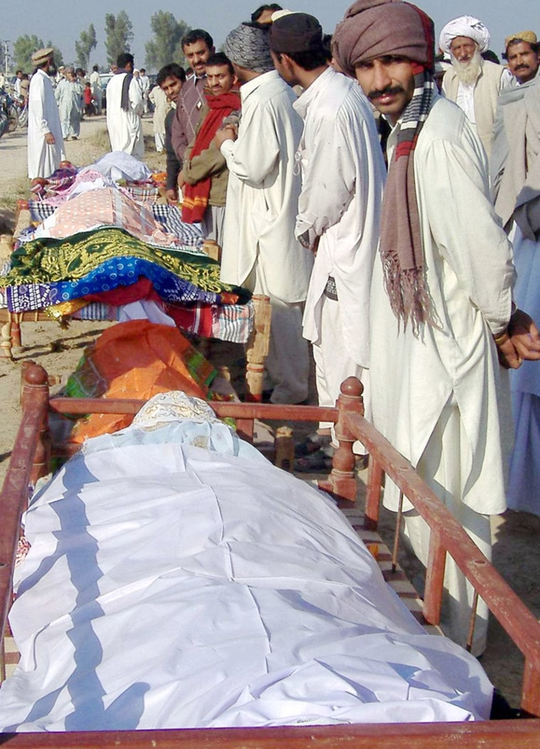 Relatives and residents stand beside the coffins of the stampede victims during a funeral in Jhok Utra village, Pakistan.