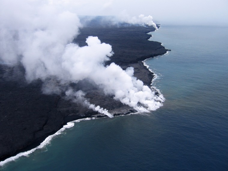 Steam is seen rising from several sites as lava enters the ocean at East Laeapuki, Hawaii. Visitors to one of the world's most active volcanoes are being kept hundreds of feet away from a 55-acre lava delta that authorities believe may soon collapse into the Pacific Ocean. 