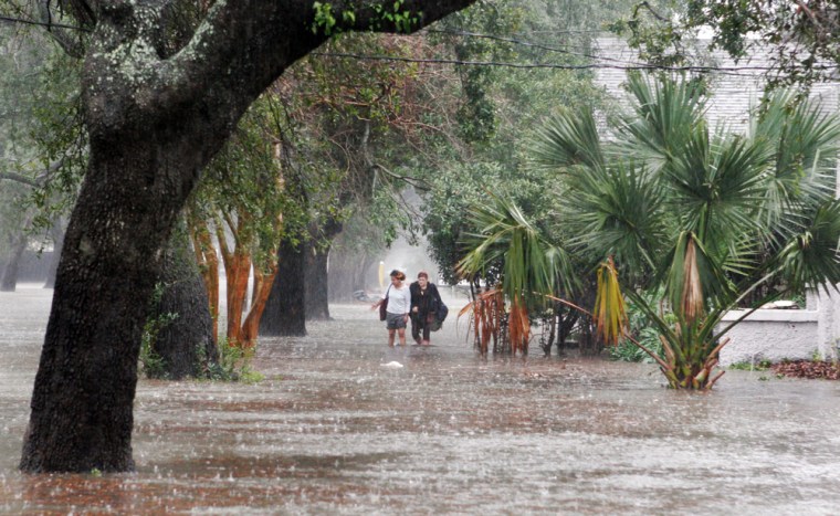 McNally Sislo, left, and Alison Mantilla walk through flooded streets of New Orleans on Thursday.