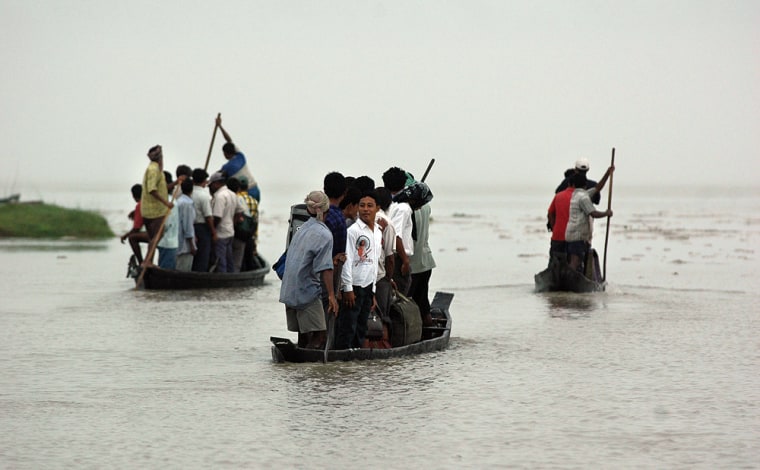 People ride on country boats through the floodwaters to catch a ferry along the river Brahmaputra in Nimatighat, about 322 kilometers (201 miles) east of Gauhati, India. A joint Indian-Chinese expedition will chart the remote Himalayan glaciers that scientists fear are rapidly being melted by global warming, threatening the great rivers that flow down from them giving life to India's vast Gangetic Plain.