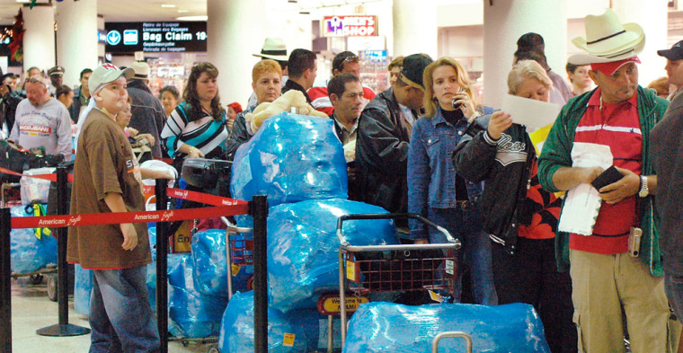 Passengers wait to check in for a charter flight to Cuba in this file photo, at Miami International Airport. A small but growing number of Cubans in South Florida are getting around the U.S. embargo that limits what can be sent to the communist island by sending their Christmas gifts through foreign Internet sites.