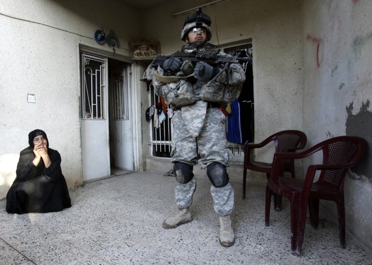 A U.S. Army soldier from Company B of the 5th Batallion, 20th Infantry Regiment, stands guard as other soldiers search a home for weapons and suspected insurgents in Baghdad on Monday.