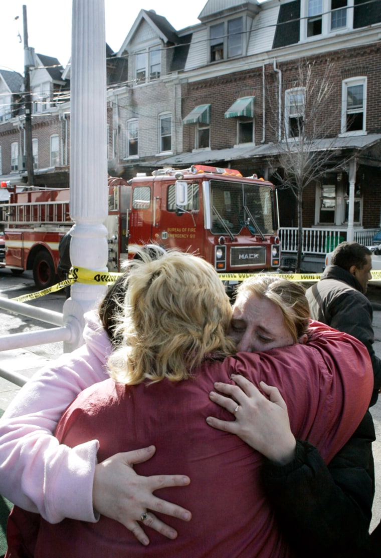 Friends of the victims of the deadly fire in Allentown, Pa., grieve Friday outside the home where five died. 