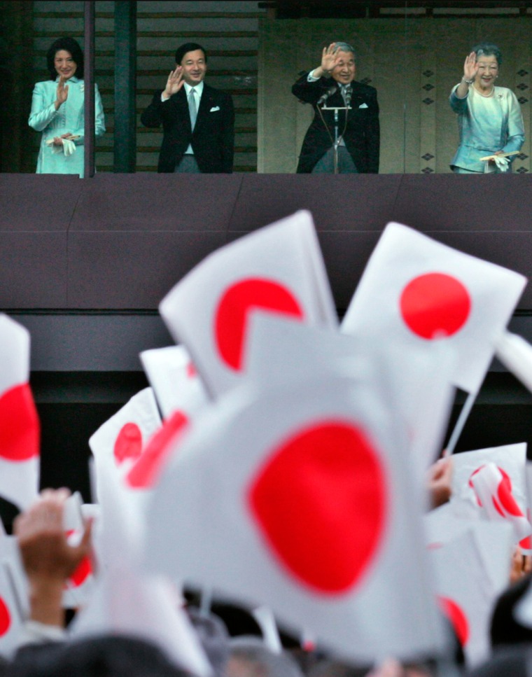 Japan's Emperor Akihito and Empress Michiko wave to wellwishers in a New Year celebration at the Imperial Palace in Tokyo
