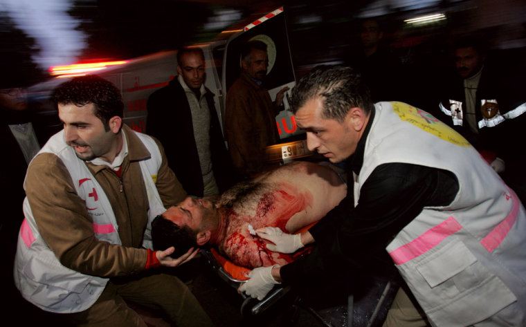 Palestinians carry a wounded man for treatment after he was injured Thursday during an Israeli army operation in the West Bank city of Ramallah.