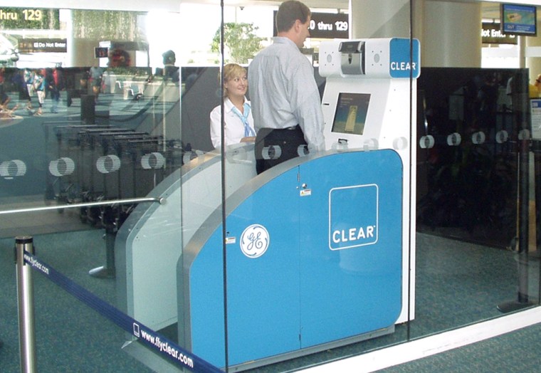 In this photo provided by Clear Registered Traveler, two Clear employees test out a shoe scanner at the Orlando International Airport. Registered travelers will be able to keep their shoes on while being checked at the ariport. 