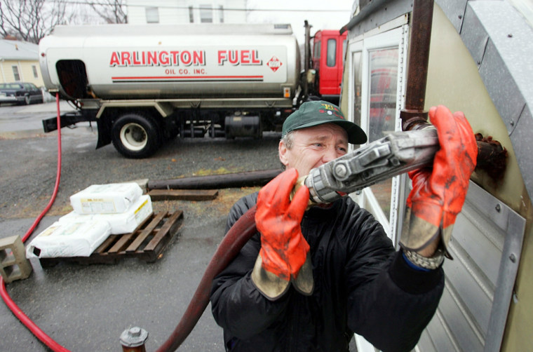 In Boston, Mass., Mike Walsh from Arlington Fuel Oil Co., Inc. hooks a fuel hose up to a pipe as he makes a delivery of heating oil. Lower prices for heating oil and unusually warm weather  have given many homeowners a break on their energy bills.