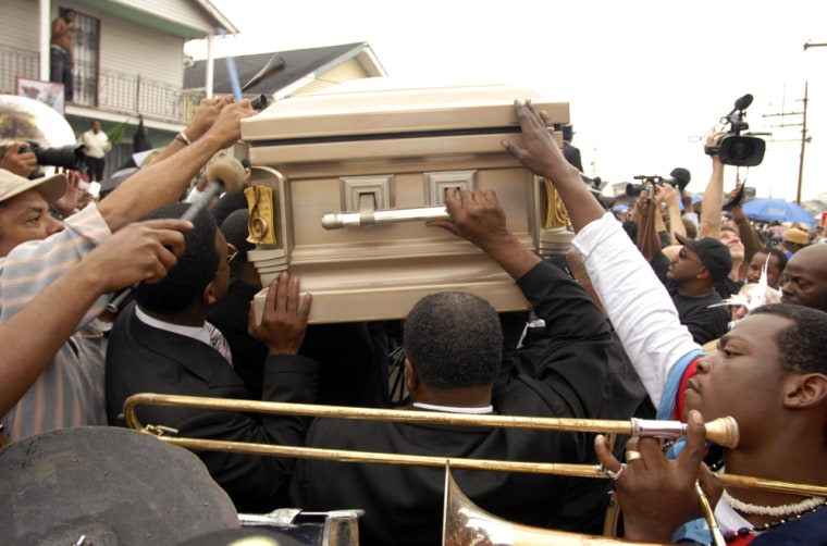 Mourners carry the casket of a 25-year-old man killed late last month.