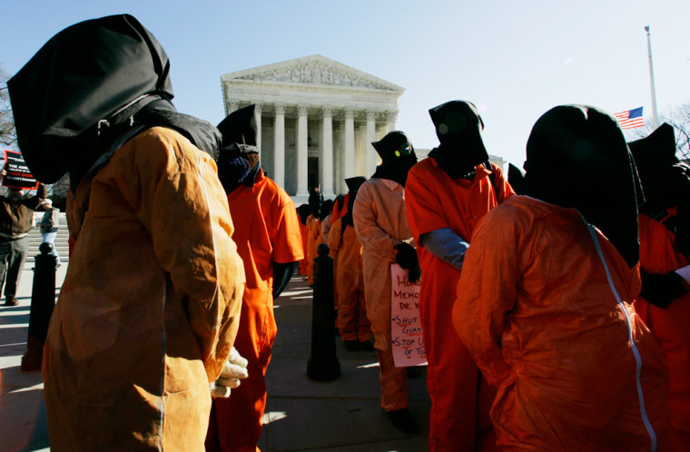 Protesters dressed similarly to Guantanamo detainees stage a demonstration in front of the Supreme Court in Washington on Thursday. Some protesters who entered a federal courtroom were arrested.