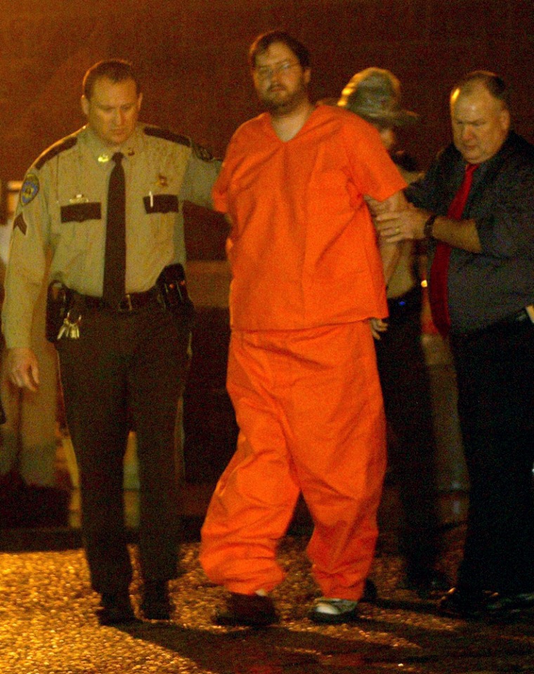 Kidnapping suspect Michael Devlin, 41, center, arrives at the Franklin County Sheriff's Department in Union, Mo., Friday, Jan. 12, 2007. Devlin was arrested after a 13-year-old boy who has been missing since Monday and a 15-year-old boy who has been missing since 2002 where found in Devlin's home in Kirkwood, Mo., Friday. (AP Photo/Post-Dispatch, Huy Richard Mach) ** MANDATORY CREDIT, MAGS OUT, NO SALES, TV OUT, ST. LOUIS METRO OUT **