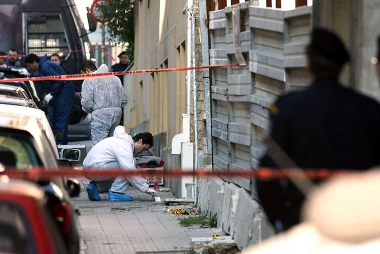 Bomb squad officers collect evidence at a construction site from where a rocket was launched in Athens on Friday.