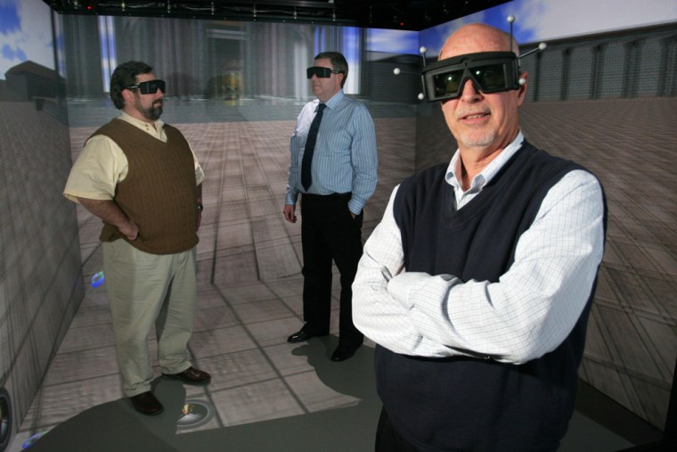 President Paul Cashen wears 3D glasses along with Ken Berta, back left, and Ken Hunter back right, in the 3D room at the Virtual Reality lab in the Joshi Center at Wright State University. Long a darling of the military and video-game industry, virtual reality is being embraced by more businesses as the sharply falling costs of computer power make it more affordable.