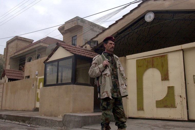 A Kurdish soldier in Irbil, north of Baghdad, stands Sunday in front of an Iranian government liaison office building where five Iranians were arrested in a U.S. military raid last week.