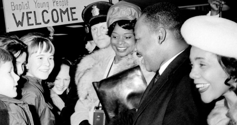 Dr. Martin Luther King, Jr., 2nd right, is flanked by his wife, Coretta Scott King, right, and his secretary, Dora McDonald, center, as King is welcomed on arrival in Oslo, Norway, in this Dec. 8, 1964 file photo. 