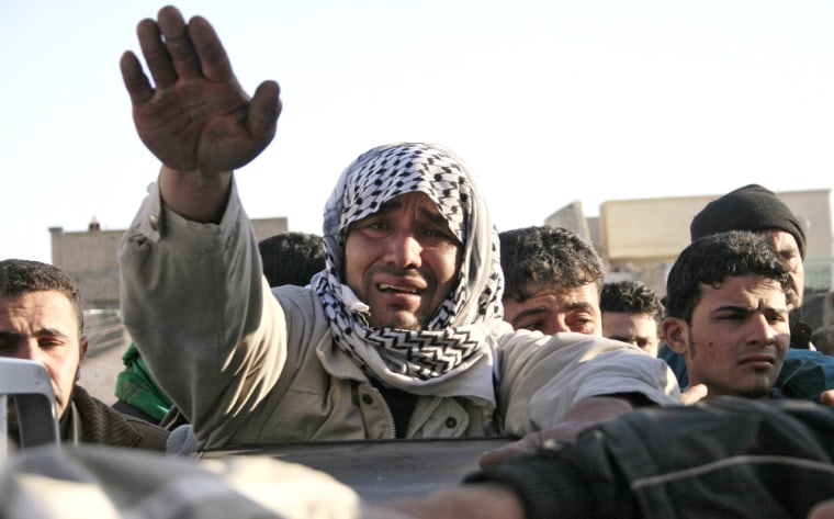 An Iraqi weeps over the coffin of his re