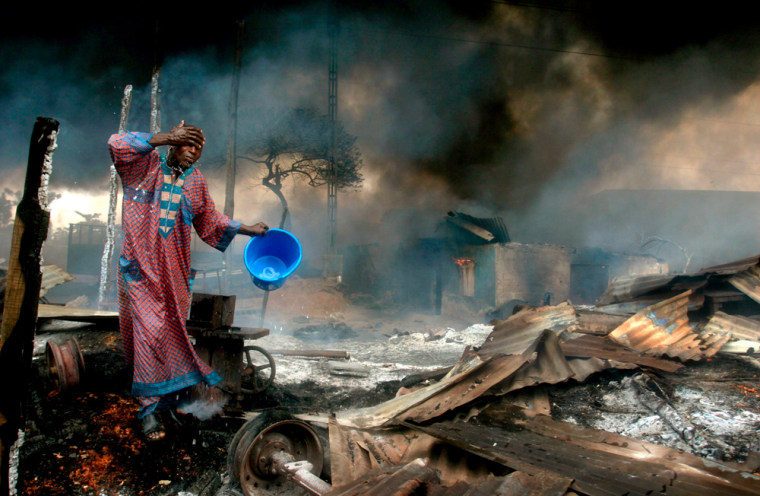 A man rinses soot from his face at the scene of a gas pipeline explosion near Nigeria's commercial capital Lagos.