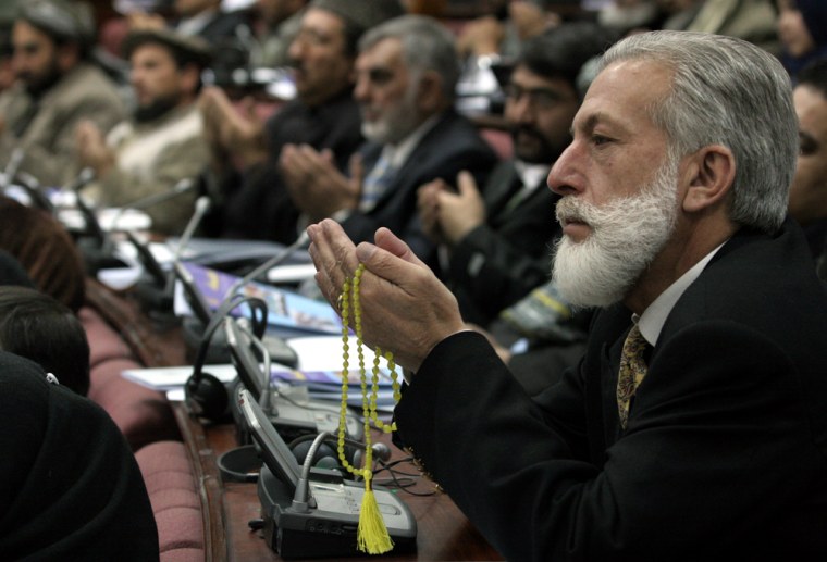 Afghan parliament members applaud Sunday after a speech by Afghan President Hamid Karzai in parliament in Kabul, Afghanistan. The Taliban will open schools in areas under their control in Afghanistan, the militant group's purported chief spokesman said.
