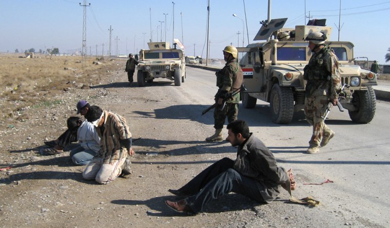 Blindfolded people are detained at the side of the road after an Iraqi army patrol came under attack in Baqouba, 60 kilometers (35 miles) northeast of Baghdad, Iraq, Wednesday Jan. 24 2007.  (AP Photo/Talal. M. al-Dean)