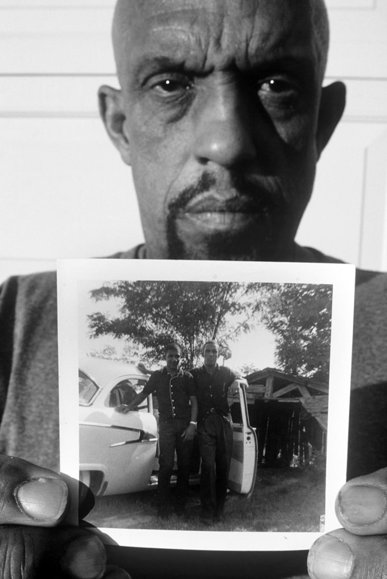 This July 2005 photo, provided by filmmaker David Ridgen, shows Thomas Moore at his home in Colorado Springs, Colo., holding a photograph of himself, right, and his younger brother Charles. The small photo was taken in 1964, shortly before Charles Moore and Henry Dee were kidnapped and killed by Ku Klux Klansmen. A federal grand jury has indicted 71-year-old James Ford Seale of Roxie, Miss., in the case.  (AP Photo/David Ridgen)
