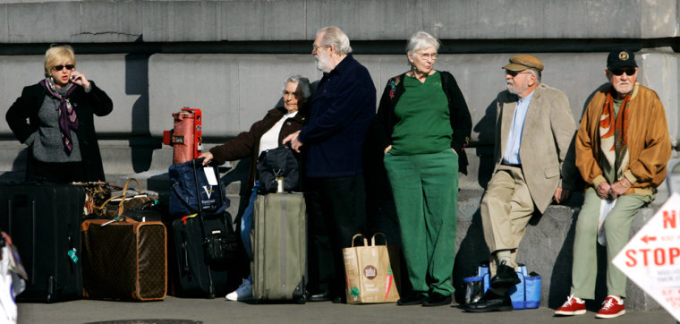 Passengers from The Queen Elizabeth 2 ocean liner wait with their bags outside Pier 35 in San Francisco, Wednesday, Jan. 24, 2007, following a flu outbreak aboard the ship. (AP Photo/Marcio Jose Sanchez)