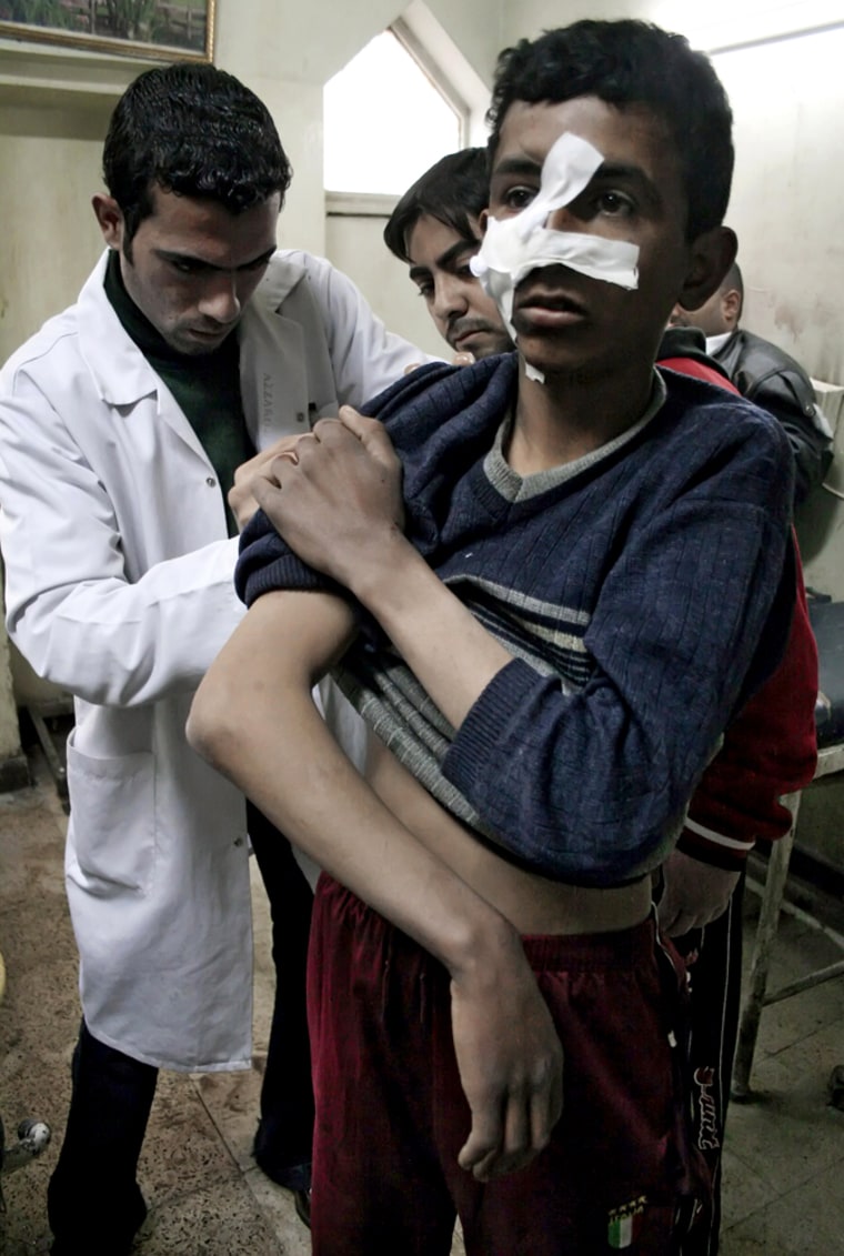 An Iraqi medic treats a wounded boy at a