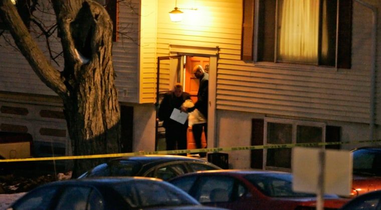 Investigators carry bags from the house in Omaha, Neb., on Sunday, where the shootings occurred.