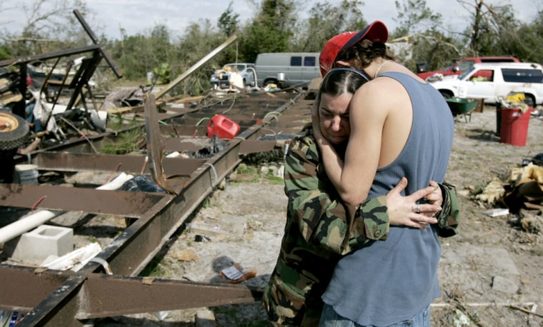 Tammy Alford hugs her son, John Carey, on Sunday after her mobile home was destroyed by storms.