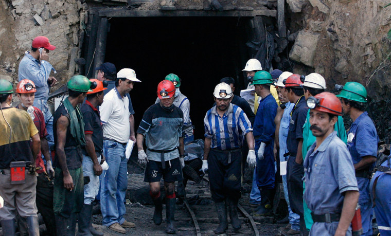 Colombian miners carries the body of one of 18 miners died in a coal mine explosion in Sardinata