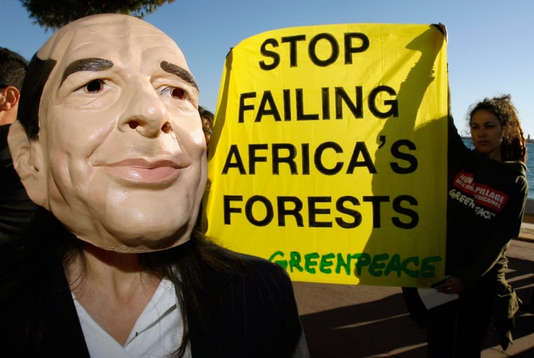 An activist from Greenpeace wears a mask of France's President Chirac during a demonstration in Cannes