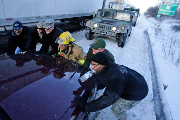 Firefighters and Pennsylvania National Guard personnel work to free a motorist's car along Interstate 78 in Bethel, Pa., Thursday, Feb. 15, 2007.