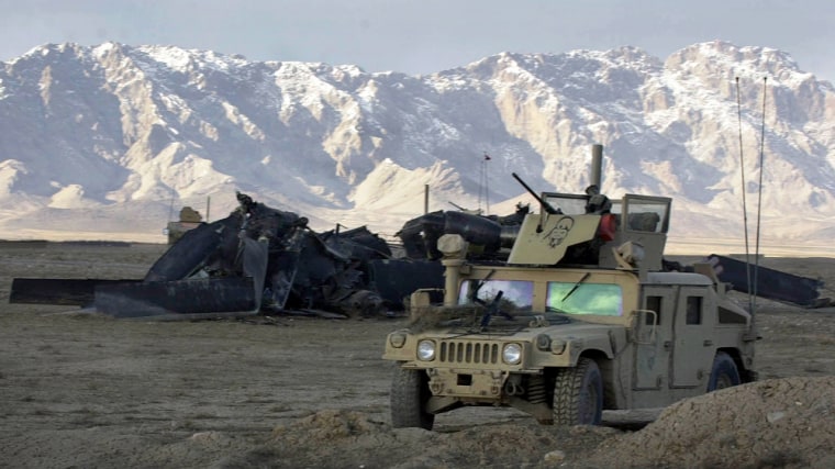 A U.S. military vehicle guards the scene of a U.S. helicopter crash in the Shahjoi district of Zabul province in southeastern Afghanistan on Sunday. Eight American troops were killed and 14 were injured in the crash. 