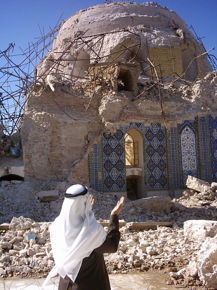 Iraqi Shi'ite prays in front of damaged Shi'ite's Golden mosque in Samarra north of Baghdad